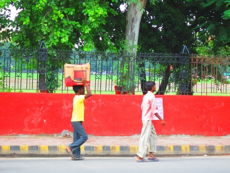 MAN CRRYING A TV SET AT HIS HEAD. SHOWS COMMERCIALISATION.  SHOT AT GANDHI MAIDAN, PATNA, BIHAR , ASIA 1515 PM ON 23.08.12 のeditorial素材