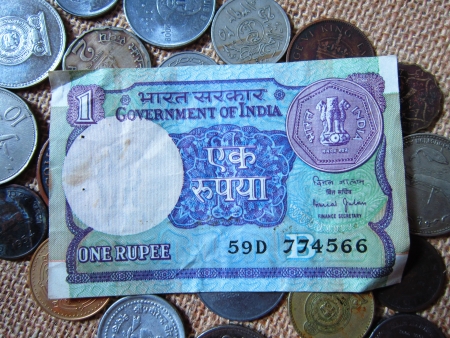 ONE RUPEE NOTE OF INDIA AMONG COINS OF DIFFERENT COUNTRIES