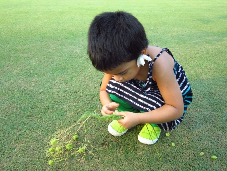 KID PLAYING ON GREEN GRASSの写真素材