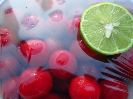 LEMON SLICE KEPT ON RED CHERRIESの写真素材