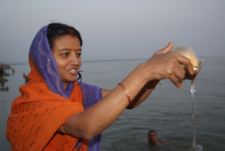 WOMAN PERFORMING MORNING GANGAPUJA AT GANGA RIVER. SHOT AT MORNING HOURS ON 15.06.11 AT PATNA, BIHAR, INDIA.のeditorial素材
