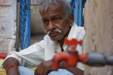 AN OLD MAN IS WAITING IN FRONT OF A WATER TAP. SHOT AT MORNING HOURS ON 15.06.11 AT PATNA, BIHAR, INDIA.のeditorial素材