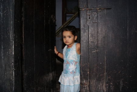 KID IN FRONT OF A DOOR. SHOT AT EVENING HOURS ON 15.06.11 AT PATNA, BIHAR, INDIA.のeditorial素材