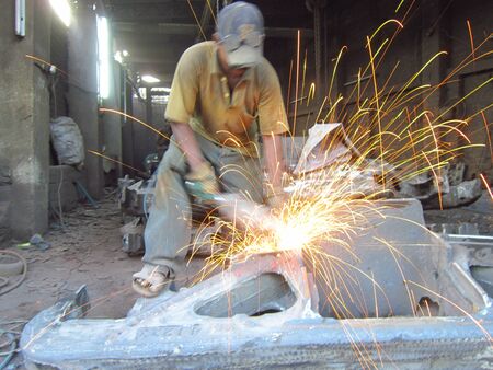 WELDING MAN REAPAIRING TRUCK AXLE.SHOT AT CALCUTTA INDIA: AFTERNOON HOURS ON NOVEMBER 12,2012.のeditorial素材