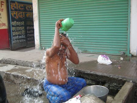 UNIDENTIFIED MAN BATHES AT STREET SIDE TAP. SHOT ON MORNING HOURS ON FEBRUARY 14, 2013 AT PATNA, BIHAR, INDIA.のeditorial素材