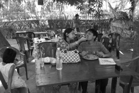 UNIDENTIFIED MOTHER SERVES FOOD TO YOUNG. SHOT AT AFTERNOON HOURS ON MARCH 18, 2013 IN NEIL ISLAND, ANDAMAN, INDIA.のeditorial素材