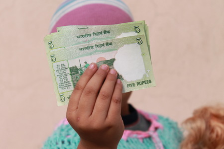 Girl shows Indian money.