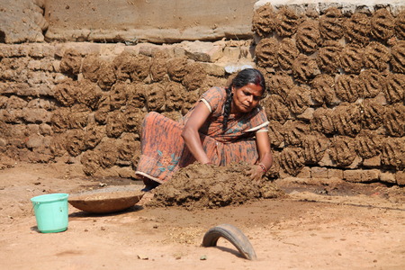 Indian woman makes cow dung cake. Shot at afternoon hours at Bokaro, Jharkhand, India on 26.02,2015.のeditorial素材