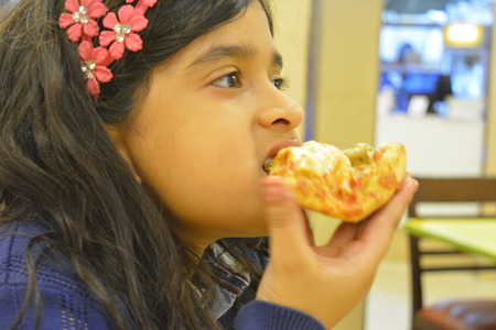 Indian girl eats Pizzaの写真素材