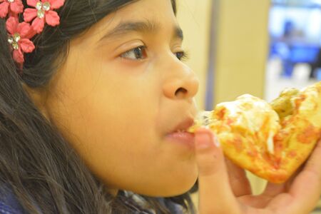 Indian girl eats Pizza. Jan 2018.の写真素材