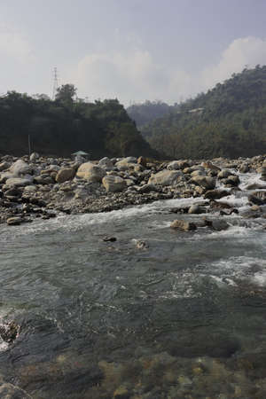 mountain stream (balason river) flowing down to the gangetic plain from himalayan foothills in the...