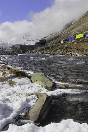 frozen mountain stream flowing through the scenic alpine valley at yumesodong or zero point, the beautiful himalayan valley located in north sikkim, indiaの写真素材