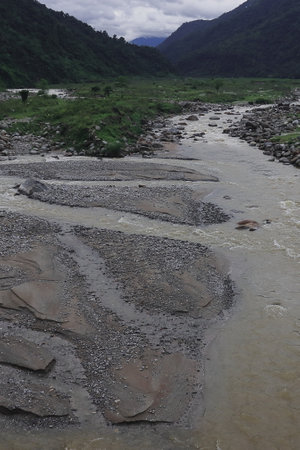 beautiful river valley, flowing stream, forest and himalaya foothills of terai - dooars region. birds eye view of flowing balason river in monsoon season at dudhiaの写真素材