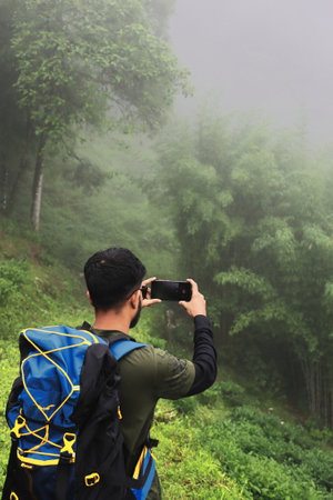 Darjeeling, West Bengal, India - 26th June 2023: Backpacking and hiking misty forest and mountains,...