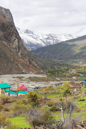 scenic landscape, snowcapped himalaya mountains and beautiful mountain village of lahaul valley, adventure traveling in himachal pradesh, indiaの写真素材