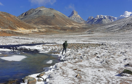 scenic mountain landscape of zero point, snowy alpine valley, frozen stream and snowcapped himalayas of north sikkim, indiaの写真素材