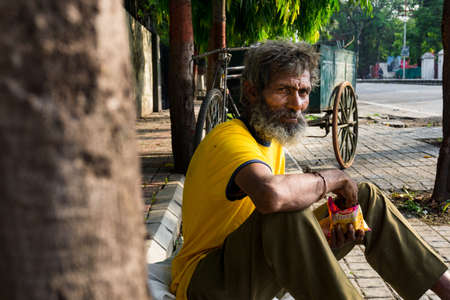 editorial dated:16 june 2020 location : dehradun India. A home less guy on the streets eating a...
