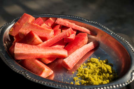 A close up shot of carrot salad served with green Indian mixed salt.