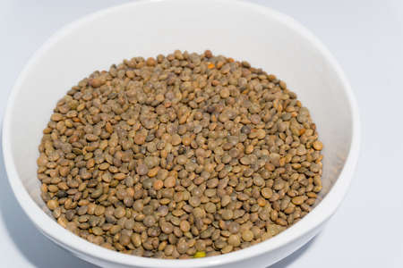 A bowl of red lentils shot in studio settings. In India it is also called black masoor dal.