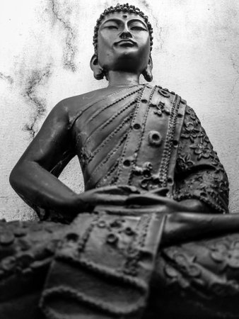 Buddha Purnima. An old Budha Statue sitting in lotus Pose with a vintage white background.の写真素材