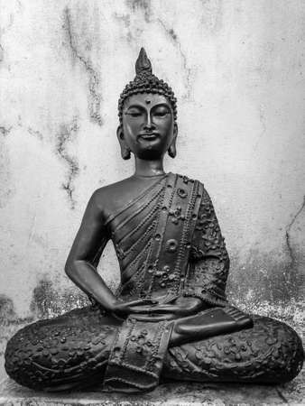 An old Budha Statue sitting in lotus Pose with a vintage white background.の写真素材