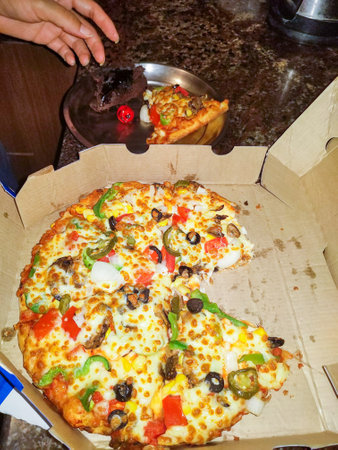 Pizza Party. Mix vegetable and mushroom Pizza with a taken out slice. Dehradun India.の写真素材