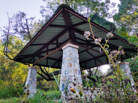 Outdoor patio pergola shade structure made of stones and metal roof top at a garden. Dehradun city India.の写真素材