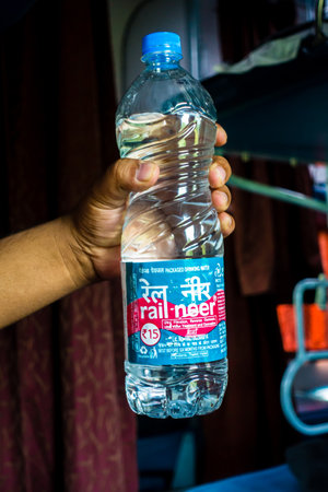 July 4th 2022 Haridwar India. A man holding Rail Neer packaged drinking water bottle offered by Indian Railways.の写真素材