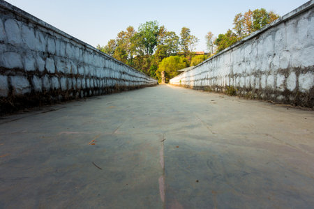 Grounded shot of a narrow sidewalk with stone walls on both sides in an outdoor park. Dehradun, Indiaの写真素材