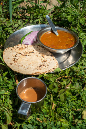Indian Roti-Sabzi ( Indian bread and vegetable curry) food platter and tea in the outdoor during camping in the Himalayas. Uttarakhand India.の写真素材