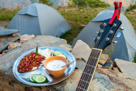 Uttarakhand camping vibes: Rajma-chawal feast with curd and salad, set against tents and guitar strums. Authentic North Indian flavors amidst nature's embrace.の写真素材