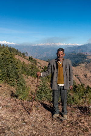 November 30th 2022. Tehri Garhwal, Uttarakhand India. Garhwali local, holding a walking stick, poses in the majestic Himalayas of Garhwalのeditorial素材