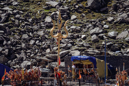 July25th2024, Himachal Pradesh, India. Religious red cloths (chunri) and tridents (trishul), symbols of Lord Shiva, against Kailash Parvat during the Mani Mahesh Kailash Yatra, a Hindu and Buddhist pilgrimage.の写真素材