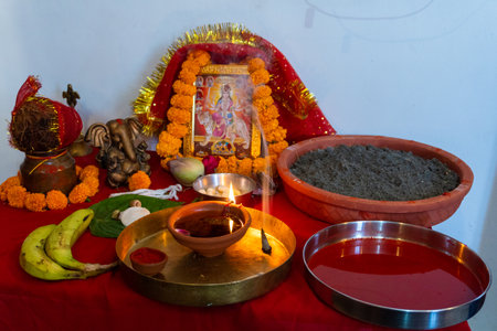 A burning mud lamp (diya) surrounded by vibrant flowers during Navratri, a Hindu festival honoring...