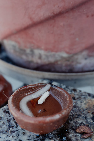 Experience the serene tradition of preparing clay pot lamps with cotton wicks dipped in oil for...