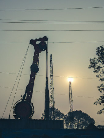 Feb15th2025 Dehradun Uttarakhand India. onstruction site machinery and towers at sunrise in...