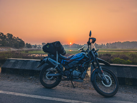 Feb15th2025 Dehradun Uttarakhand India. Adventure motorcycle loaded with luggage bags against morning sunrise, outskirts of Dehradun, Asan Barrage Lake, Uttarakhand, India.の写真素材