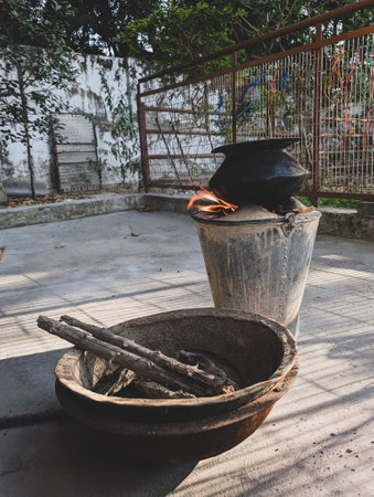 A traditional cooking scene with a backyard mud stove, angeethi, firewood, and a cast iron vessel in Uttarakhand, India.の写真素材