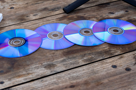May 1st 2024, Dehradun Uttarakhand India. Obsolete set of CDs on a wooden table. Digital transition...