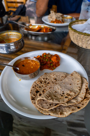 North Indian platter featuring roti, dal, and mixed vegetables served on a dining table. Healthy...