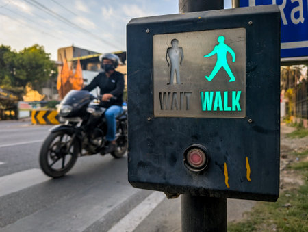 Pedestrian crossing signal on Rajpur Road with a motorcyclist in the background.