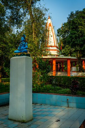 Blue stone Lord Shiva statue in meditation with temple dome backdrop Dehradun Uttarakhand Indiaの写真素材