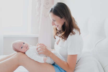 Newborn is lying on his mother's lap view of the cameraの写真素材