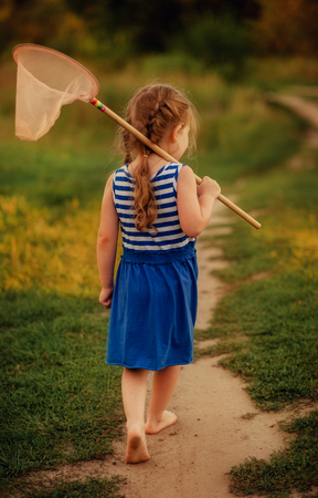 girl with a net walking barefoot about the grass in the forestの写真素材