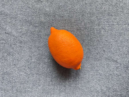 Orange unusual lemon on a gray background. On the textureの写真素材
