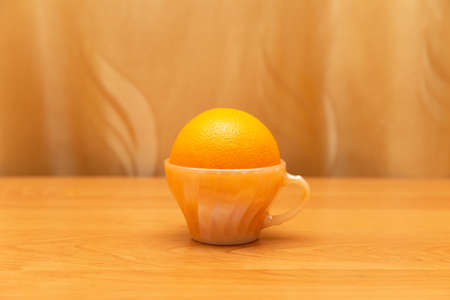 Orange lies inside the cup, orange tea, cup in the middle of the picture, on the background of the...