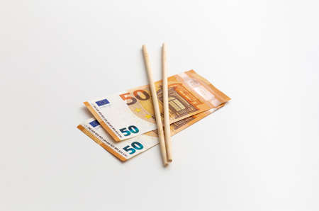 Chinese sticks are on euro, made of wood, production, on the white background