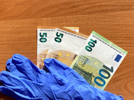 Blue latex gloves and 50 and 100 euro bills. For the cashier or seller. The bottom of the picture, sale of latex glovesの写真素材
