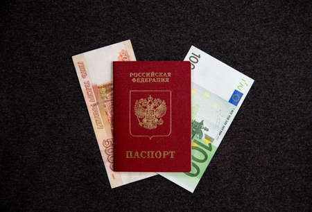 Russian passport and euros, rubles, flatlay. Currency exchange. Dark textile background. 100 eurosの写真素材