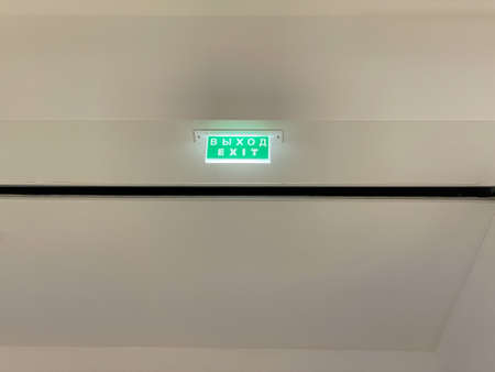 A small light green sign - Exit The inscription is in Russian on the top and in English belowの写真素材